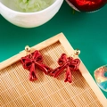 Christmas red bow earrings with gold studs on a festive green background - Red