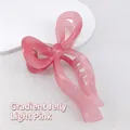 Detail of the translucent gradient pink bow hair claw clip on a white stone surface - Gradient Jelly Light Pink