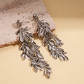 Detailed view of silver leaf tassel earrings resting on natural textured stone background - Silver (Silver Earring Post)