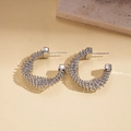 Macro detail of silver C-shape twisted metal earrings with a spiral spring texture - Spiral Textured C-Shape Style / Silver