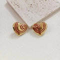 Golden heart earrings with red radial enamel texture on elegant stone display - Red