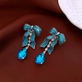 Detail of bow-shaped teal earrings with sparkling crystal accents on dark velvet fabric - 16# Silver Pin - Silver - Blue - Bow Gemstone