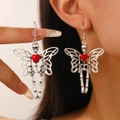Detail shot of gothic silver skeleton butterfly earrings with red heart accent on model - Gothic Butterfly Skull Earhooks (G032) / White Gold