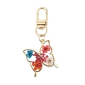 Detalle de un colgante de mariposa con flores secas reales en resina transparente - Ramo Rojo Mariposa Naranja