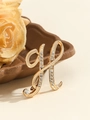 Elegant gold letter H brooch with white rhinestones on a decorative tray - Gold Letter H