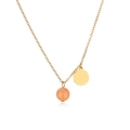 Macro view of gold-plated chain featuring an orange stone bead and round metal pendant - Gold Yellow Chalcedony