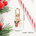 Detalle de llavero de reno navideño con acabado de esmalte y colgante de perla fina - Alce