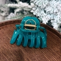 Detail shot of a dark green pumpkin bow hair claw clip on a rustic wooden tray - Pumpkin Shape