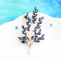 Elegant gold leaf branch brooch with marquise-cut dark blue crystals on ceramic - Gold and Navy Blue
