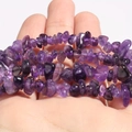 Detailed macro view of natural purple amethyst irregular crushed stone beads on hand - Amethyst Chips