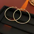 Dettaglio di grandi orecchini a cerchio dorati su un espositore in pelle nera - Orecchini a Cerchio Grandi con Perno in Argento (50mm)