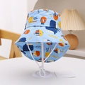 Detail of light blue kids sun hat featuring cartoon whale prints and adjustable chin strap - Blue Octopus