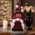 Détail d'un gnome de Noël avec sucre d'orge, bonnet en tricot rouge et texture en peluche - Gnome rouge avec sucre d'orge femme