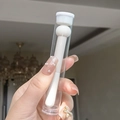 Detail of mushroom head concealer sponge brush in clear protective packaging tube - With Tube / White