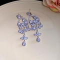 Macro view of vintage silver tassel earrings with clear cubic zirconia in a chandelier style - Silver Hollow Heart Water Drop Tassel Earrings