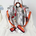 Detail showing a nautical print silk scarf styled on a white shirt and grey handbag - Orange Sailboat