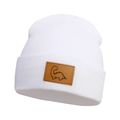 Detail of white knit beanie for kids featuring a brown leather patch with dinosaur pattern - White