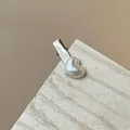 Dettaglio del fermaglio in lega argento con perla bianca a cuore su carta naturale - Forcina / Modello a Cuore Piccolo