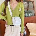 Close-up of white corduroy waist bag with front flap pocket on green cardigan outfit - White