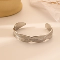 Dettaglio di un bracciale rigido aperto in argento a forma di piuma in acciaio inox - Piuma d'argento