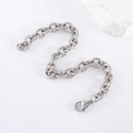 Collana a catena spessa argentata con maglie rotonde e chiusura a moschettone su bianco - Bracciale
