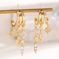 Gold hoop earrings with zircon stars, moon, and spike charms on a warm background - Star and Moon Geometric Element Dangle Earrings (3035) / KC Gold