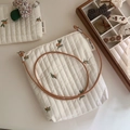 Close-up of quilted floral crossbody bag with fruit embroidery and leather strap - Crossbody Phone Bag