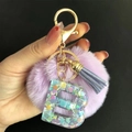Portachiavi con pompon viola e lettera B in resina con paillettes su sfondo nero intenso - Lettera B