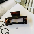 Detail of dark brown amber hair claw clip with geometric hollow rectangular design - Glossy Red Brown