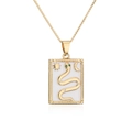 Vue détaillée d'un pendentif totem serpent doré avec zircons et motifs soleil et lune - Or Émail Blanc