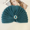 Detail of dark peacock blue knitted headband with large blue gemstone and lace trim - Green