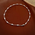 Dettaglio di una collana con maglie in argento a spirale e perle bianche eleganti - Catena a clavicola con giunzione di perle corte a mezzaluna d'argento (HN4694)