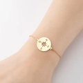 Minimalist gold compass bracelet with NSEW star pendant on a female wrist model - 365-Star Compass