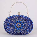 Detailed macro view of blue rhinestone evening bag with floral gemstone and gold handle - Blue