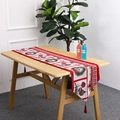 Détail d'un chemin de table de Noël rouge avec couronnes festives, motifs et glands - Style D Guirlande