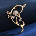 Detail of a luxury gold brooch with crystals and a black bead on a dark fabric background - Note Starfish