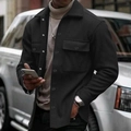 Detail of black workwear jacket with flap pockets and snap buttons over beige turtleneck - Black