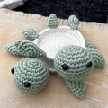 Handmade crochet turtle coaster set with green and beige yarn on a stone plate - Emerald