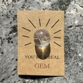 Close-up of healing crystal gem on kraft paper gift card with You are a Real Gem text - White Crystal