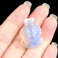 Miniature opalite sea turtle carving with iridescent purple and milky white tones - Synthetic Opal