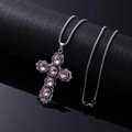 Vintage silver cross necklace with pink oval gemstones on a black textured background - Pink Cross