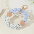 Llavero de pulsera con cuentas de silicona azul cielo y madera con aro dorado - Azul Cielo