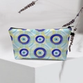 Detail of waterproof Evil Eye makeup bag with zipper on a white geometric display stand - Blue Yellow Evil Eye