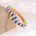Dettaglio macro del bracciale placcato oro con gemme blu e bianche a taglio marquise - Blu e Bianco