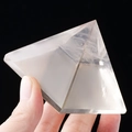Clear natural white crystal pyramid statue with polished faces on black background - 8cm