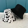 Detail of printed panda bucket hat and plain black sun hat with fine stitching detail - M / White