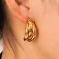 Elegant 18K gold plated 304 stainless steel triple hoop earrings for women shown on ear - Triple Intertwined Hoops (BJGE0703)