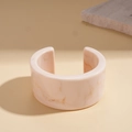 Macro detail of amber marbled resin cuff bracelet featuring a minimalist C-shape design - Large White (Marble Pattern)