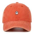 Close-up of ghost embroidery on washed cotton baseball cap with vintage texture - Orange