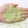 Light green bow-shaped pearl beads for DIY craft decoration held in hand for scale - Light Green